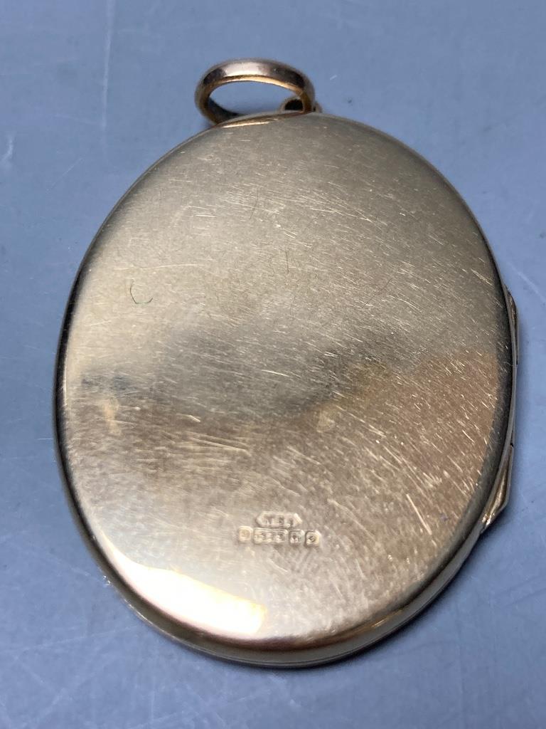 A 1960's engraved 9ct gold mounted oval pendant locket